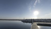 the dock is empty with rocks in the background as the sun is setting over the water