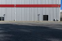 a view of some doors at a building's entrance that is empty outside and has red painted siding