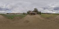 the panoramic image shows an empty farm field with a truck in it's driveway