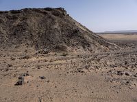 a truck on a dirt road in the desert with rocks and stones on the ground