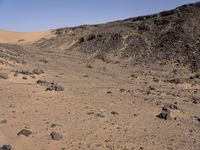 a truck on a dirt road in the desert with rocks and stones on the ground