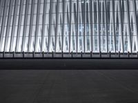 there is an empty floor in front of a tall building with many windows, and several glass walls