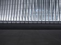 there is an empty floor in front of a tall building with many windows, and several glass walls