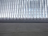 there is an empty floor in front of a tall building with many windows, and several glass walls