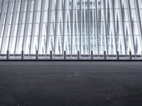 there is an empty floor in front of a tall building with many windows, and several glass walls