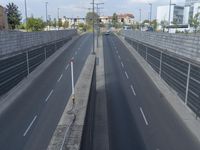 this freeway is empty as it winds down from the station in its lane, with cars passing