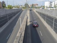 this freeway is empty as it winds down from the station in its lane, with cars passing