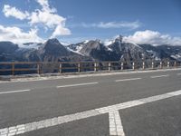 an empty freeway with mountains and mountains in the background, and a sign directing on traffic in front of them