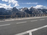 an empty freeway with mountains and mountains in the background, and a sign directing on traffic in front of them