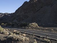 an empty freeway next to the mountains in the desert, with no one going anywhere