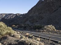 an empty freeway next to the mountains in the desert, with no one going anywhere