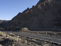 an empty freeway next to the mountains in the desert, with no one going anywhere