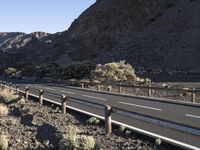 an empty freeway next to the mountains in the desert, with no one going anywhere