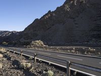 an empty freeway next to the mountains in the desert, with no one going anywhere