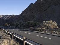 an empty freeway next to the mountains in the desert, with no one going anywhere