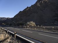 an empty freeway next to the mountains in the desert, with no one going anywhere