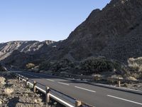 an empty freeway next to the mountains in the desert, with no one going anywhere