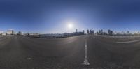 the sun is shining down over an empty freeway in the city with tall buildings behind