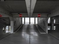 an empty parking garage with two red stop signs attached to the doors and no parking signs on the sides