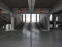 an empty parking garage with two red stop signs attached to the doors and no parking signs on the sides