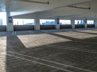 empty parking garage with parking space on two sides of the walkway and roof area to the left