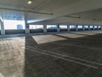 empty parking garage with parking space on two sides of the walkway and roof area to the left