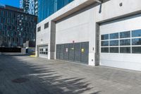 a empty garage is set up on the side of a street in front of a modern building