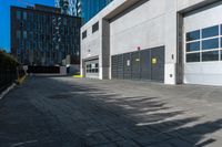 a empty garage is set up on the side of a street in front of a modern building