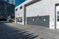 a empty garage is set up on the side of a street in front of a modern building