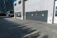 a empty garage is set up on the side of a street in front of a modern building