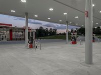 the inside of an empty gas station with columns and pillars with nozzles on the floor