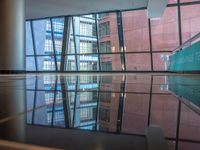 empty glass platform in the middle of an atrium with several buildings outside, reflecting the reflection