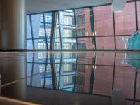 empty glass platform in the middle of an atrium with several buildings outside, reflecting the reflection