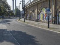 the empty street is full of graffiti as it winds down the road in the sunlight