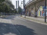 the empty street is full of graffiti as it winds down the road in the sunlight