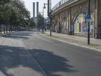 the empty street is full of graffiti as it winds down the road in the sunlight