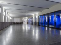 the empty hallway with many doors on each side of it is bright blue and grey