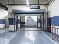 a building has a long line of empty hallways that are painted blue and white, with large signs above them