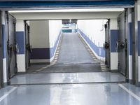 a building has a long line of empty hallways that are painted blue and white, with large signs above them