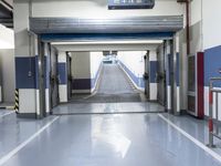 a building has a long line of empty hallways that are painted blue and white, with large signs above them