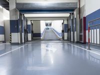 a building has a long line of empty hallways that are painted blue and white, with large signs above them