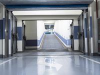 a building has a long line of empty hallways that are painted blue and white, with large signs above them