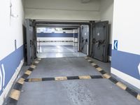 a building has a long line of empty hallways that are painted blue and white, with large signs above them