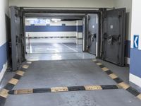 a building has a long line of empty hallways that are painted blue and white, with large signs above them