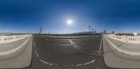 a fish eye lens shot of a empty highway in california with a bright sun on top