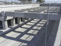 an empty highway with multiple parking lanes and elevated bridge above it in a sunny day