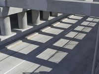 an empty highway with multiple parking lanes and elevated bridge above it in a sunny day