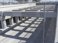 an empty highway with multiple parking lanes and elevated bridge above it in a sunny day