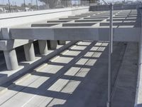 an empty highway with multiple parking lanes and elevated bridge above it in a sunny day