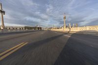 a shot of an empty highway going down the road to cityscape in the distance